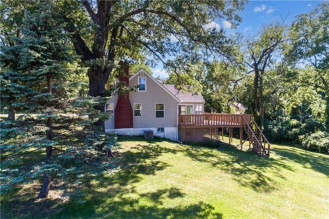 rear view of property featuring stairway, a lawn, and a wooden deck