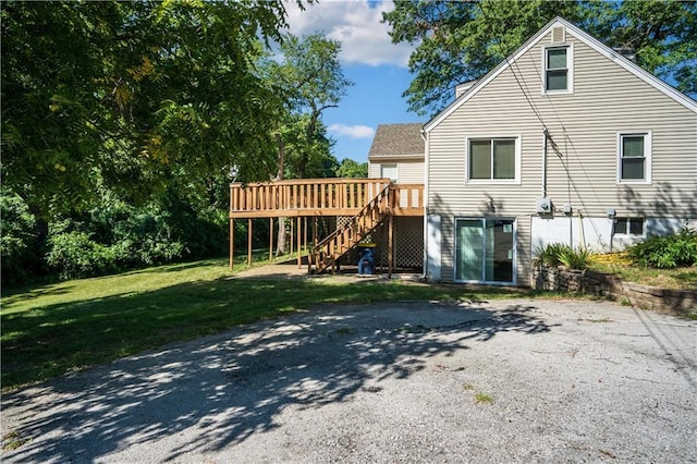 rear view of house featuring stairs, a yard, and a wooden deck