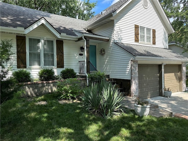 view of front of property featuring concrete driveway, an attached garage, a front lawn, and roof with shingles