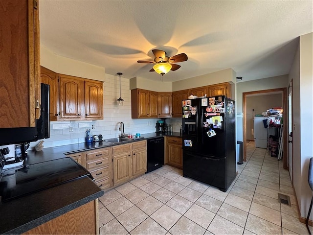 kitchen with tasteful backsplash, visible vents, dark countertops, black appliances, and a sink