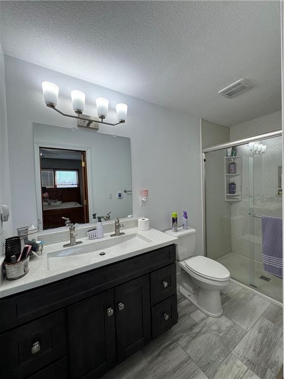 full bathroom with vanity, visible vents, a stall shower, ensuite bathroom, and toilet