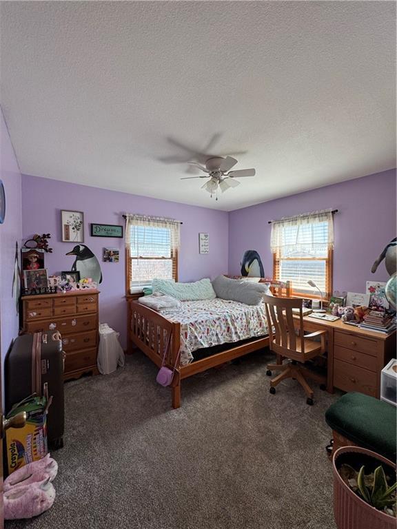 carpeted bedroom featuring a textured ceiling and ceiling fan