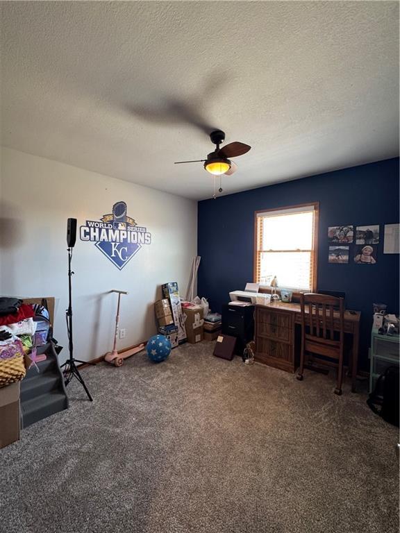 carpeted bedroom with a textured ceiling and ceiling fan