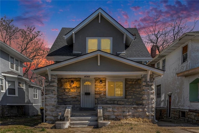 view of front of home with a porch and stone siding