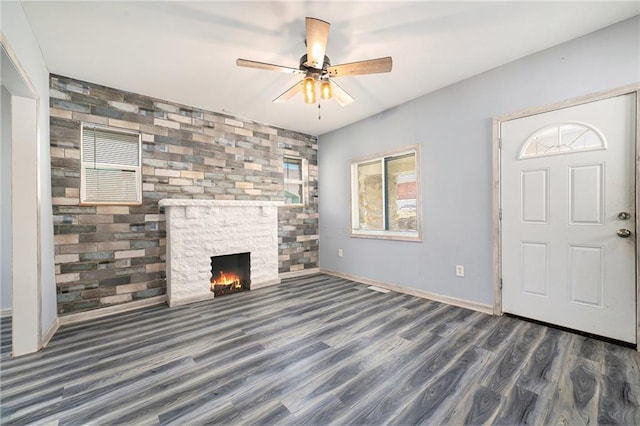 unfurnished living room with a fireplace, baseboards, ceiling fan, and wood finished floors