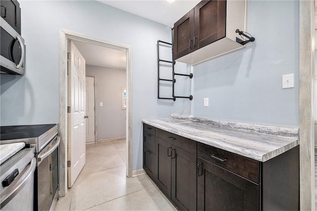 kitchen with dark brown cabinetry, stainless steel appliances, and baseboards