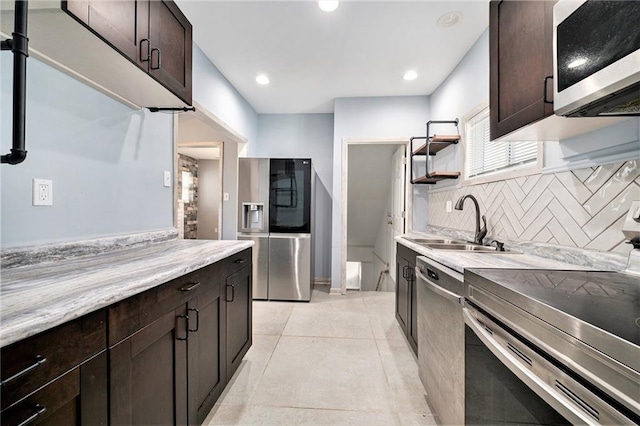 kitchen with a sink, stainless steel appliances, dark brown cabinetry, and decorative backsplash