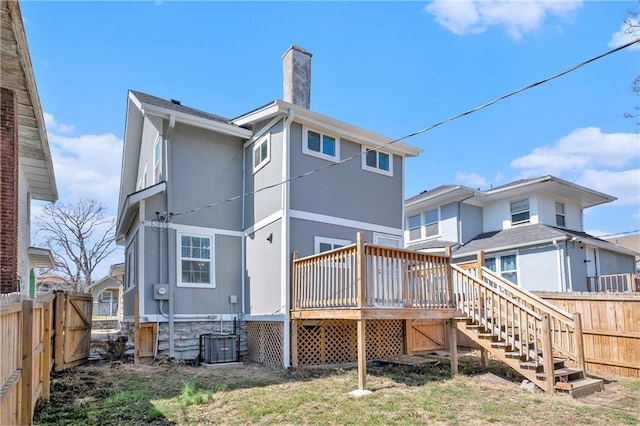 back of house with a wooden deck, central air condition unit, a chimney, and fence