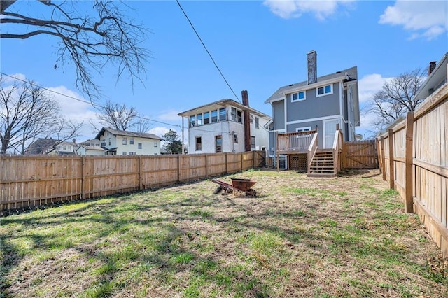 view of yard with a fire pit, a fenced backyard, and a wooden deck