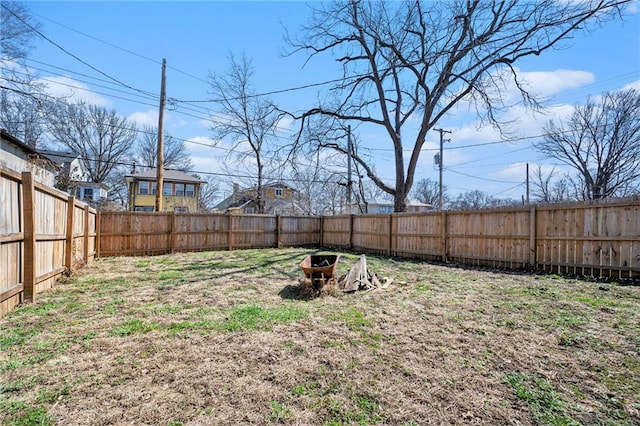 view of yard featuring a fire pit and a fenced backyard