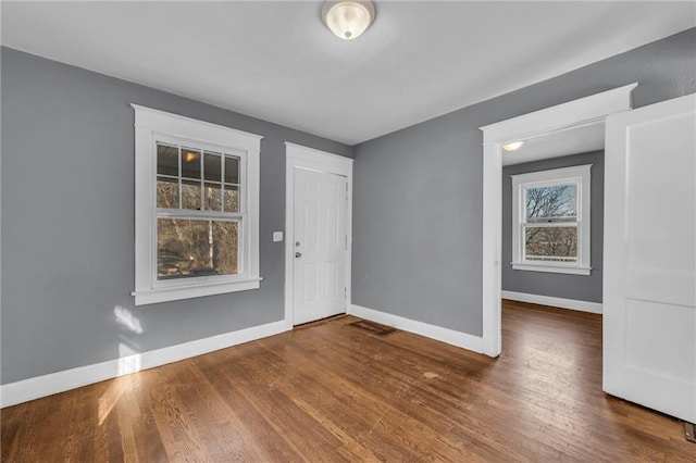 entryway with baseboards and wood finished floors