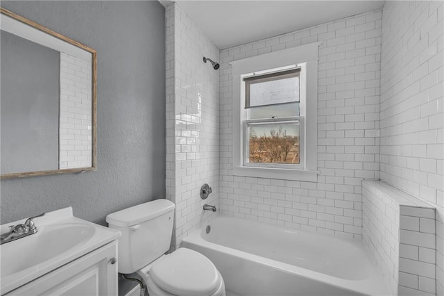 bathroom with vanity,  shower combination, toilet, and a textured wall