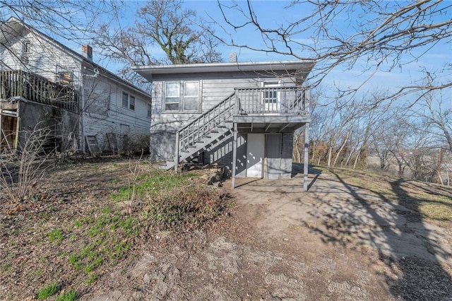 view of front of property with stairway, driveway, and a wooden deck