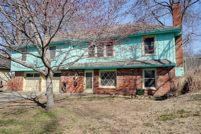 view of front facade with driveway, board and batten siding, an attached garage, a shingled roof, and a chimney