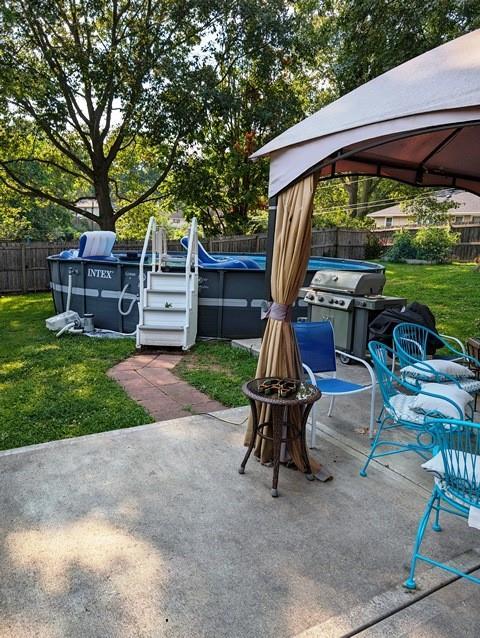 view of patio with a gazebo, area for grilling, a fenced in pool, and a fenced backyard