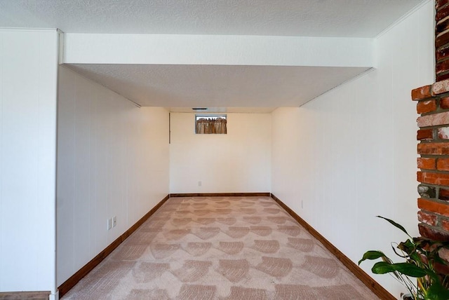 finished basement featuring light carpet, baseboards, and a textured ceiling