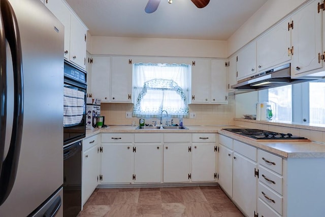 kitchen featuring tasteful backsplash, black appliances, under cabinet range hood, white cabinetry, and a sink