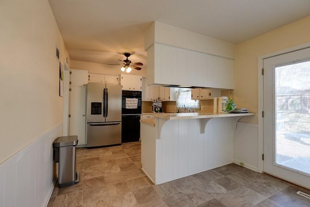 kitchen featuring wainscoting, a peninsula, a ceiling fan, and stainless steel fridge with ice dispenser