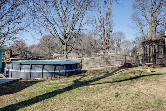 view of yard with fence and a fenced in pool