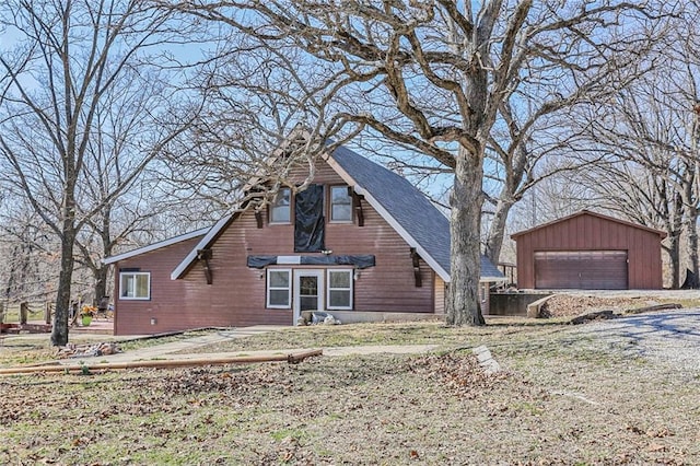 exterior space with an outbuilding, a garage, and roof with shingles