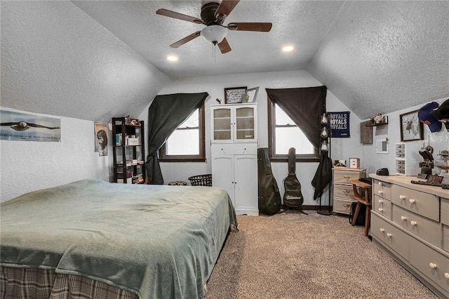 bedroom with a textured ceiling, a ceiling fan, lofted ceiling, light carpet, and a textured wall