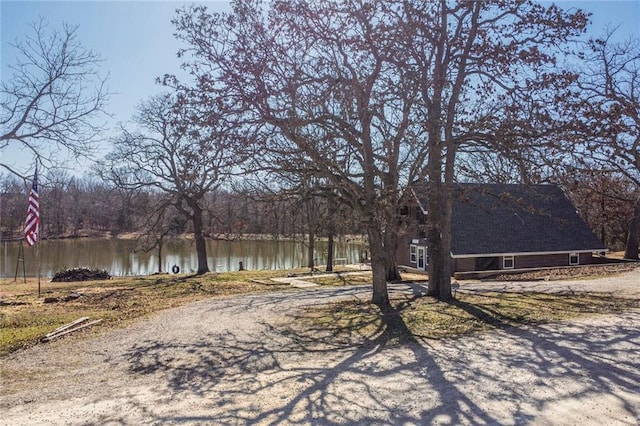 exterior space with a water view and dirt driveway