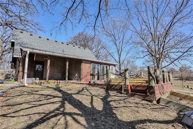 back of property featuring roof with shingles