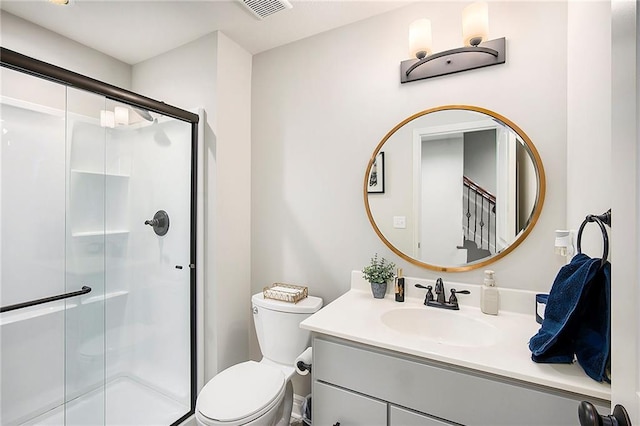 bathroom featuring visible vents, a shower stall, vanity, and toilet