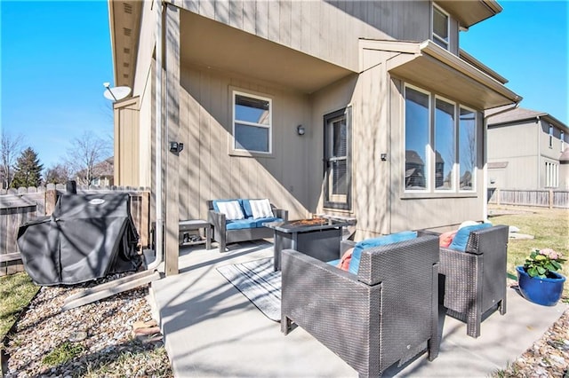 view of patio with area for grilling, an outdoor living space with a fire pit, and fence