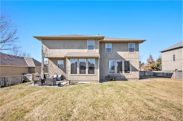 rear view of property featuring a fenced backyard, a lawn, and a patio