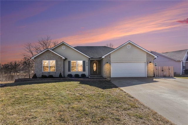 ranch-style home with concrete driveway, an attached garage, and a lawn