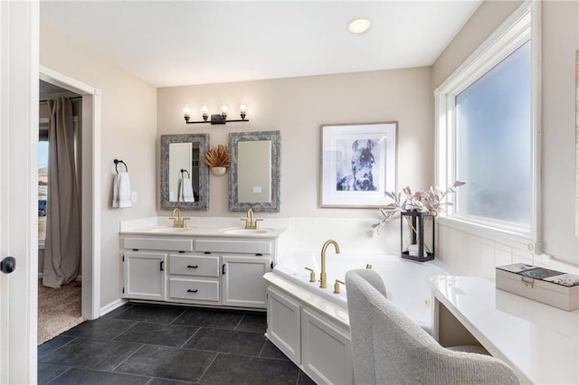 bathroom with a garden tub, double vanity, baseboards, and a sink