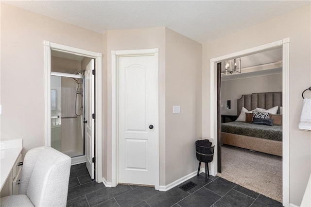 bedroom with baseboards, dark tile patterned flooring, an inviting chandelier, and dark carpet