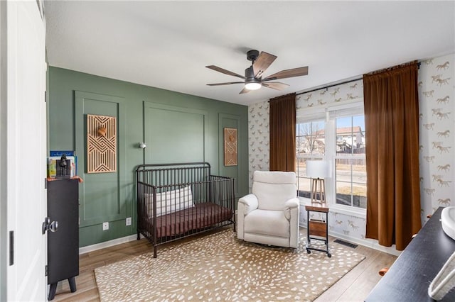 bedroom with visible vents, wallpapered walls, and light wood-style floors