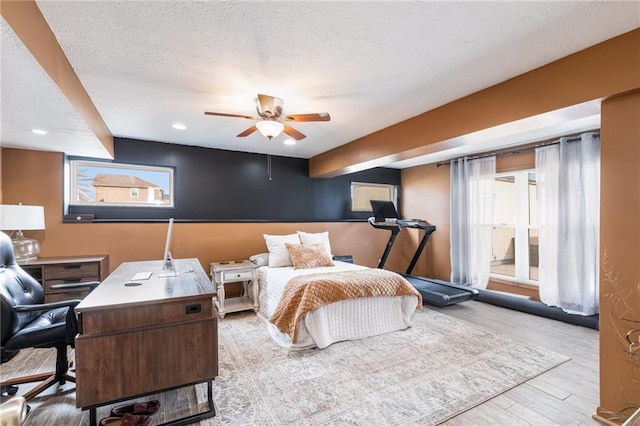 bedroom with recessed lighting, multiple windows, a textured ceiling, and wood finished floors