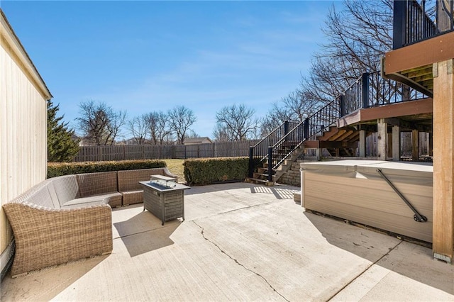 view of patio featuring stairway, a hot tub, outdoor lounge area, and fence