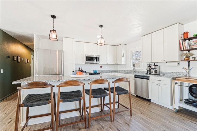 kitchen featuring open shelves, appliances with stainless steel finishes, and white cabinets