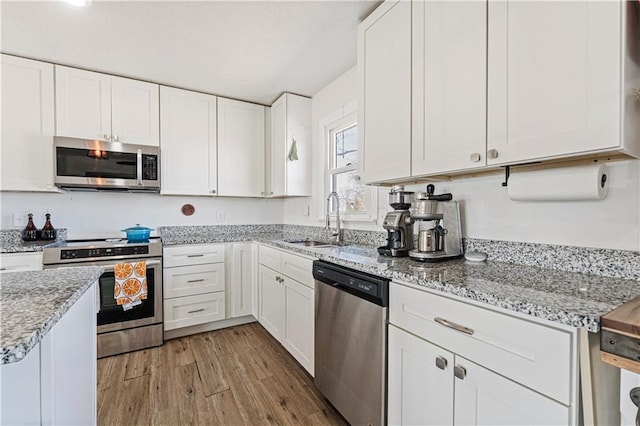 kitchen featuring a sink, white cabinetry, appliances with stainless steel finishes, and light wood finished floors