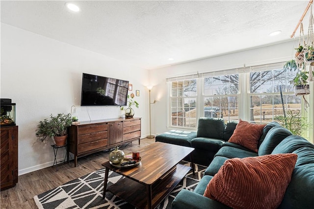 living room with recessed lighting, wood finished floors, baseboards, and a textured ceiling