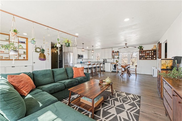 living area with a ceiling fan, dark wood finished floors, radiator heating unit, recessed lighting, and a textured ceiling