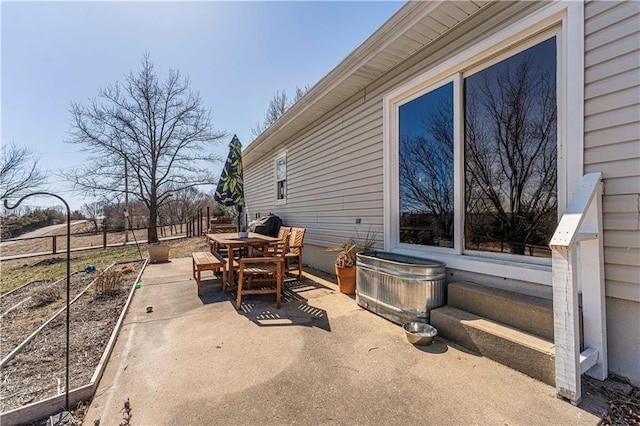 view of patio featuring outdoor dining area and fence