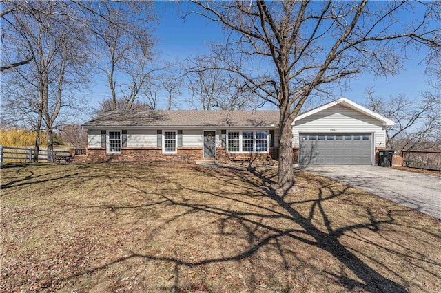 ranch-style home featuring aphalt driveway, an attached garage, fence, and brick siding