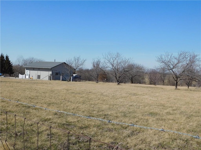 view of yard with a rural view and fence