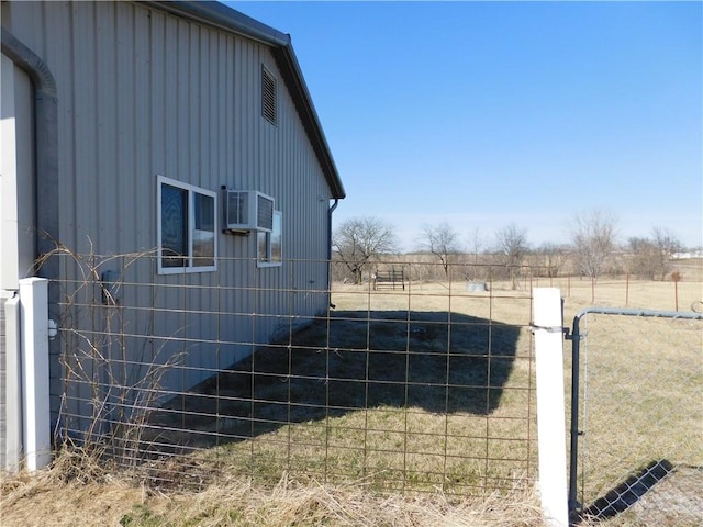 view of side of home with a rural view, cooling unit, and fence