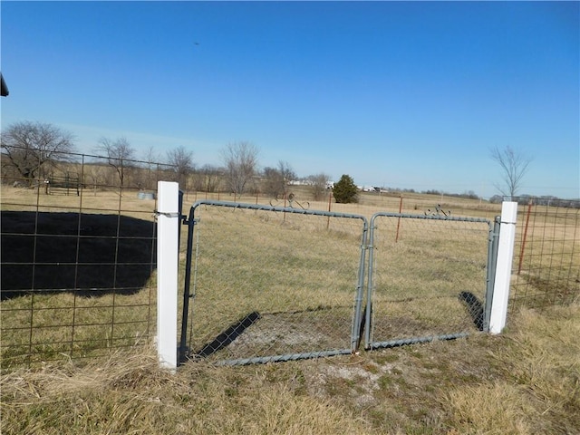 view of gate featuring a rural view and fence