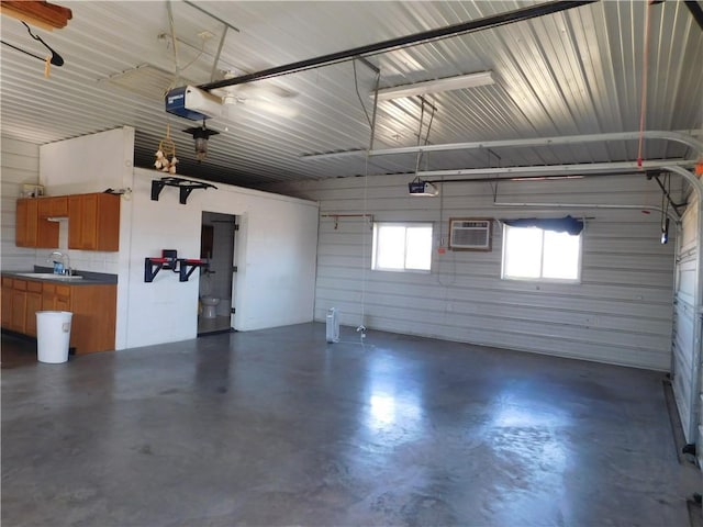 garage with a sink, a garage door opener, metal wall, and a wall mounted AC