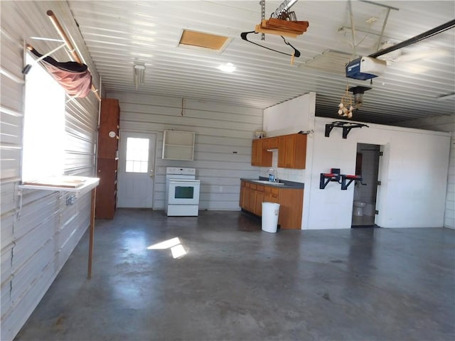 garage with metal wall, a garage door opener, and a sink