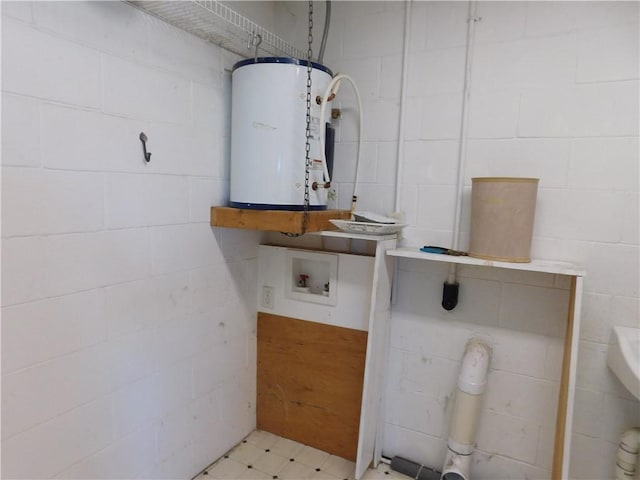 interior space featuring concrete block wall and water heater