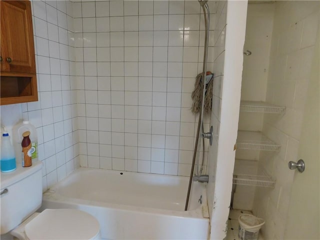 bathroom with toilet and tile walls