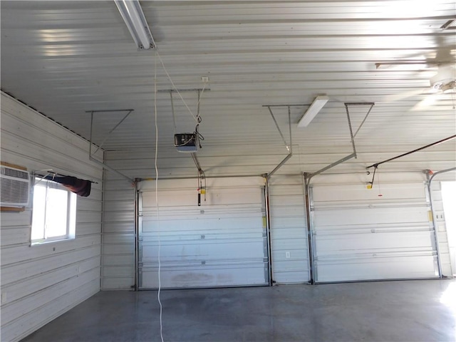 garage with an AC wall unit and a garage door opener